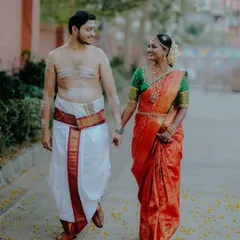 Venkatesh and Shilpa walk hand-in-hand after their traditional Tamil wedding ceremony. The groom's sacred markings and the bride's vibrant saree tell a story of culture and love.