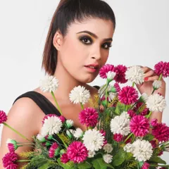 A beauty shot of a model with dramatic eye makeup holding a bouquet of flowers, perfect for a makeup artist collaboration or a model's portfolio.