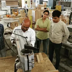An instructor explains the functionality of a radial arm saw. Students learn to make precise crosscuts and angled cuts on this versatile machine.