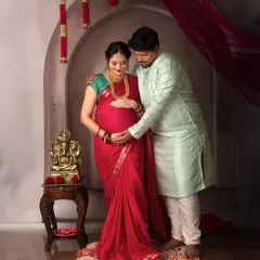 A beautiful couple's portrait in traditional attire. The partner's hand gently on her bump symbolizes his love and support on this sacred journey.