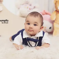 A charming close up of a baby boy in our 'Teddy Bear World' studio setup. The soft, fluffy rug and his adorable bowtie make for a picture perfect moment.