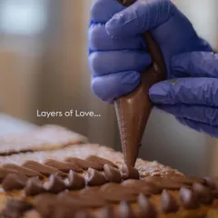 Layers of love. A glimpse of our pastry chef meticulously piping chocolate frosting, showing the care that goes into every single one of our creations.