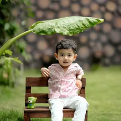 Finding some shade under a big leaf. We love using natural elements in our garden to create unique and creative compositions for your child's photoshoot.