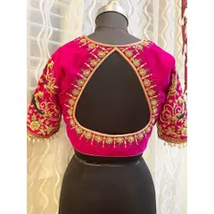 This vibrant pink blouse features a modern triangular back opening, framed with exquisite zardosi and peacock motifs on the sleeves, adding a royal touch to the design.