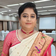 A close-up of the mother of the bride, ready for the Haldi ceremony. Her makeup is fresh and natural, with a soft lip color that complements her beautiful Paithani saree. Her hair is styled in a classic, neat updo.