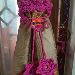 This curtain tie-back is made with a band of beautiful magenta flowers. The matching ties end in smaller flowers, creating a lush, floral look for your curtains.