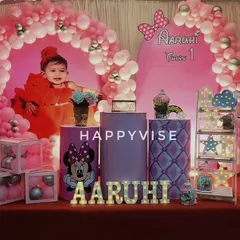 A sweet Minnie Mouse theme for Aarohi's first birthday. The heart-shaped pink balloon arch and custom backdrop with her photo make it an extra special celebration.