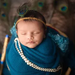Celebrating Janmashtami with a beautiful Little Krishna setup. This baby girl looks so serene, dressed with a peacock feather and pearls, embodying the divine theme.