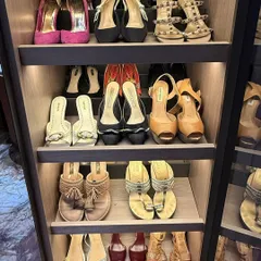 A close-up of a beautifully organized shoe collection on lit shelves. We arrange shoes by type and color, making it easy to find the perfect pair for any outfit.