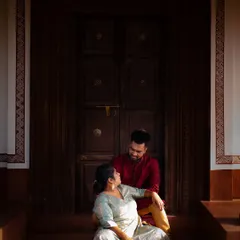 A beautifully composed portrait of a couple sharing a moment on the steps of a traditional home. The use of natural light highlights their connection and the rich texture of the surroundings.