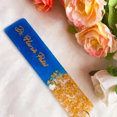 A bookmark is a thoughtful gift for any book lover. This one was made for a doctor, featuring his name in gold on a deep blue background with a gold leaf accent.