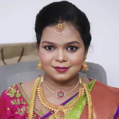 A close up of Pallavi's baby shower makeup. The look features a soft pink and purple eyeshadow blend with a defined eyeliner and a matching berry lip color, creating a festive and beautiful look for her celebration.
