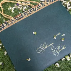 Elegance in its simplest form. This deep teal invitation bag features the couple's names in a graceful gold foil script. The top border has a complementary pattern, adding a touch of classic design to this modern and stylish carry-bag invite.