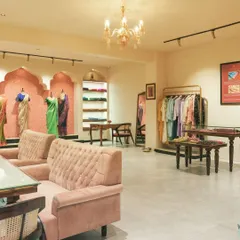 This overall view shows the layout, which balances retail display with customer comfort. A grand chandelier adds a touch of luxury, while the distinct zones for browsing and seating create a seamless shopping experience.