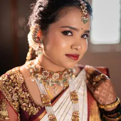 A close-up of a classic South Indian muhurtham look for Lavanya. The focus is on traditional details, with bold kohl-rimmed eyes, a classic red lip, and skin that looks luminous and real, even under the bright ceremony lights.