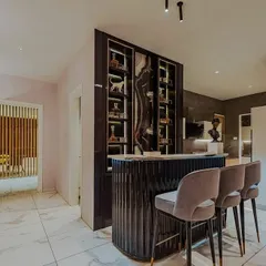 This home bar is designed as a sophisticated focal point. The back-lit panel with its dramatic stone pattern is the main feature, with integrated vertical lighting in the shelving to make the glassware and bottles glow.