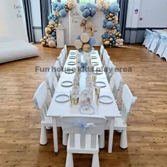 A close-up view of our elegant white table and chair setup for a "Teddy Bear" themed first birthday. The chairs are decorated with delicate blue sashes, showing how easily our classic furniture can be customized.