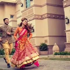 A candid and joyful moment of the couple running and laughing together during their wedding festivities.