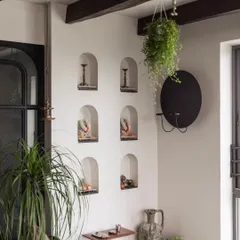 Another corner of the sunroom project, featuring arched wall niches displaying small idols and candle holders. This shows how even small, curated pieces can create a beautiful and spiritual atmosphere.