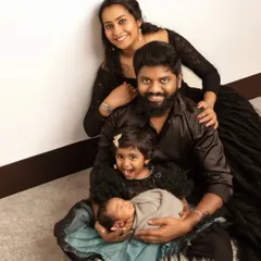 The complete family of four, happy and relaxed. This portrait captures the parents and big sister doting on the newest member of their family, a peacefully sleeping newborn.
