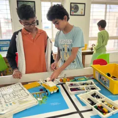 Collaboration is key to success in engineering. Here, two of our students work together, combining their ideas and skills to build and refine their robot for the World Robot Olympiad, learning valuable teamwork skills along the way.