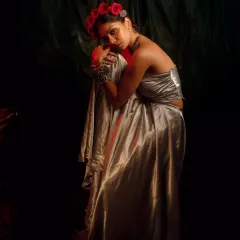 From the 'INARA' series, this look combines a liquid silver skirt and top with heavy, oxidized silver jewelry. The contrast of modern fabric and traditional accessories, along with the floral crown, creates a bohemian-luxe vibe.