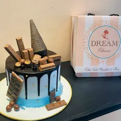 A chocolate lover's dream, this Belgian chocolate overload cake is adorned with KitKats, chocolate bars, Maltesers, and an inverted cone for a dramatic effect.