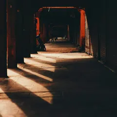 Light and shadow create a dramatic pattern in a dark corridor in Jaipur. This image is about finding beauty in quiet, empty spaces and having the patience to see how light can transform a scene.