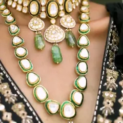 A detailed shot of the layered polki necklaces from the Om Jewellers cocktail look. Layering jewelry is a great way to create a statement, and here it adds depth and luxury to the ensemble.