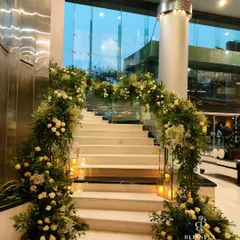 A grand and elegant staircase welcome for Akhil and Zoee's reception. We draped the railings with lush garlands of white roses, baby's breath, and greenery, interspersed with warm candle lanterns for a classic, romantic look.