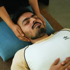 We believe in a personal touch. Here, a student receives a gentle adjustment during Savasana, helping them to relax completely and absorb the benefits of their practice.