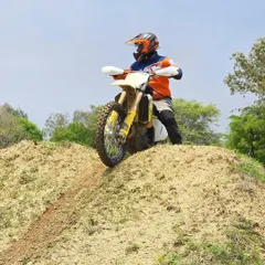 A rider pauses at the peak of a man-made hill, a common obstacle in our Level 2 training. Mastering throttle control and body positioning is key to conquering these challenges.