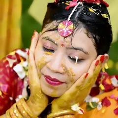 The bride's serene moment amidst the colourful chaos of her Haldi. This candid shot captures her happiness and the beauty of the turmeric paste against her skin.
