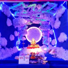 For a more creative Ganpati theme, I designed this celestial look. It features a deep blue backdrop with soft, cloud-like textures and a glowing moon behind the idol, all highlighted with cool blue LED strip lighting for a magical effect.