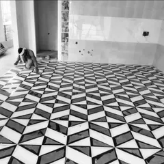 A work-in-progress shot of a super cool geometric floor pattern being laid. This intricate black and white marble inlay required precision and skill, resulting in a 3D-effect pattern that is both modern and visually captivating.