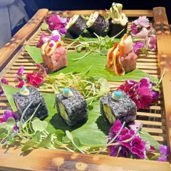 We specialize in international cuisines, presented with artistry. This platter showcases a variety of our handcrafted sushi rolls, garnished with edible flowers and microgreens, demonstrating our commitment to both authentic flavor and visual appeal.