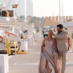 A sweet surprise on the marina. The groom covers the bride's eyes before revealing the beautifully decorated yacht for their pre-wedding celebration.