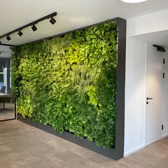 This large-scale interior green wall demonstrates our ability to cover extensive surfaces with vibrant, healthy foliage. It acts as a natural work of art, elevating the entire aesthetic of this commercial building's interior.