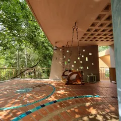 This outdoor room is designed to filter the east sun through a perforated 'jali' wall and a filler slab ceiling. The two swings offer a place for quiet reflection, suspended between the home and the lush garden canopy.