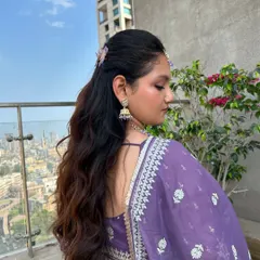 An effortless yet special half-up hairstyle. This look features soft, defined waves with the top section pinned back, showing off the hair's length and volume.