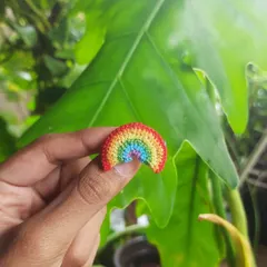 A simple and sweet micro-crochet rainbow pin. It's a small but powerful symbol of queer joy and pride, perfect for any jacket or bag.