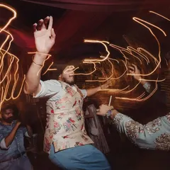 The energy on the dance floor is what makes a celebration unforgettable. This shot, with its dynamic light trails, captures the pure joy and abandon of guests dancing the night away at a Mehendi & Cocktail party.