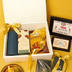 Celebrate the sibling bond with a personal touch. This Raksha Bandhan hamper features personalized passport holders with names, along with premium chocolates and a festive diya, all presented in a classic white gift box.
