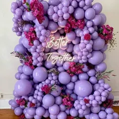 This is a popular choice for modern engagements. I created a dense wall of purple balloons in various sizes, accented with fresh flowers and a bright 'Better Together' neon sign for a chic photo backdrop.