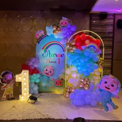 A complete Cocomelon theme for a first birthday, one of our most requested designs for toddlers. It features character cutouts of JJ and friends, a rainbow balloon arch, and a large light-up marquee number '1'.