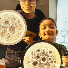 Sisters showing off the moon lamps they created together. This workshop is a fantastic bonding experience, resulting in a beautiful keepsake.