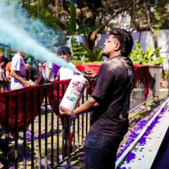 Getting hands-on with a color extinguisher to spray the crowd during a Holi party. My goal is to be part of the action, not just behind the decks.