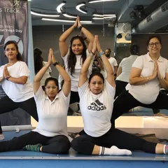 A beautiful group yoga pose, showcasing the strength, balance, and teamwork we build in our classes.