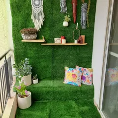 For this balcony, the client wanted a full green carpet look. I covered both the floor and the back wall in high-quality artificial grass, creating a built-in seating area and a vibrant backdrop for the decor, which includes ethnic masks and a dreamcatcher.