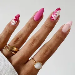 A beautiful floral manicure perfect for summer. This design features a mix of solid bright pink nails and accent nails with a '70s-inspired floral pattern in shades of pink and red.